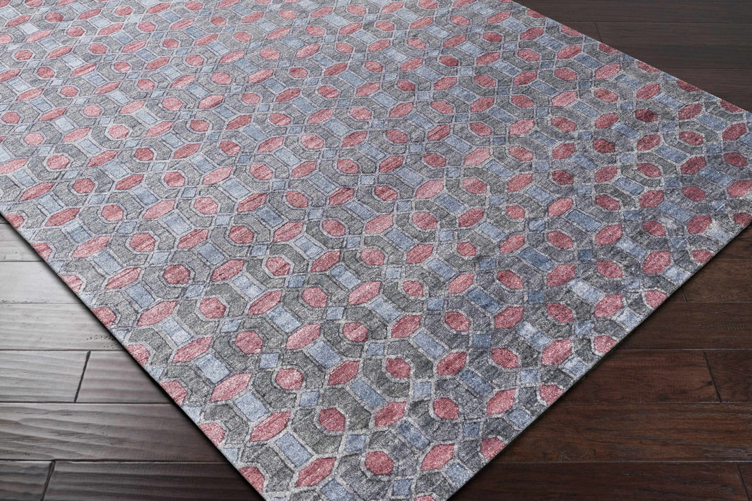 Gray geometric hand-knotted rug with red accents, lying on a hardwood floor
