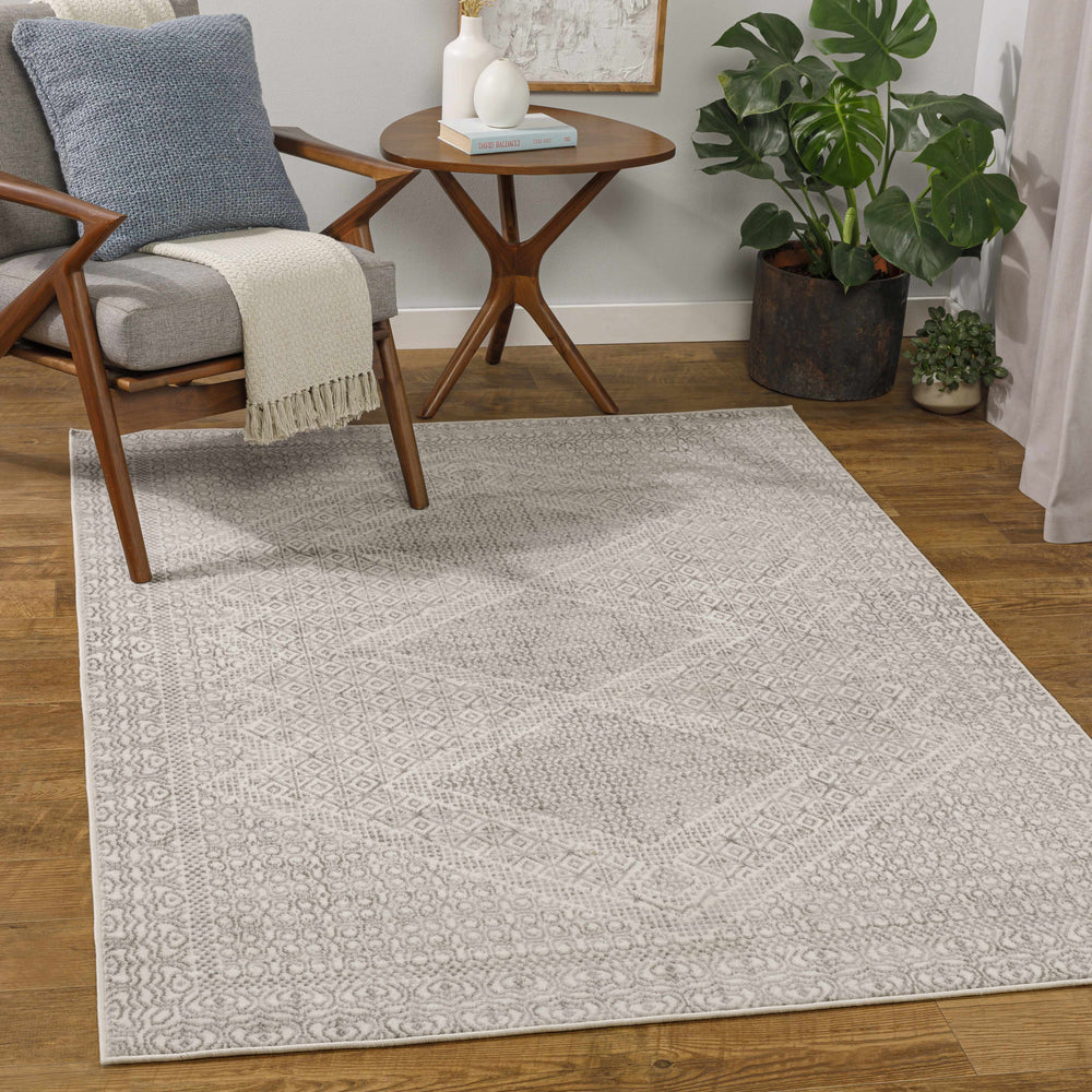 Ivory and gray geometric area rug with textured diamond medallion design.