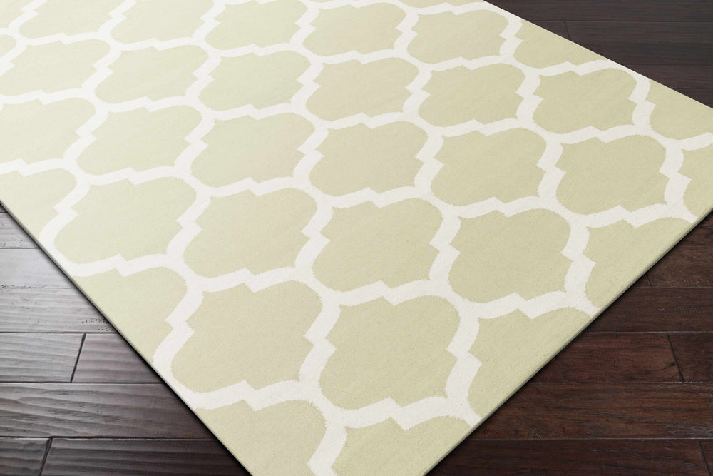 Green rectangle area rug with white quatrefoil trellis pattern, diagonal corner view