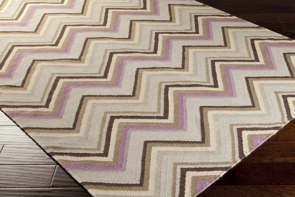 Beige area rug with multicolor chevron pattern and visible rug edge