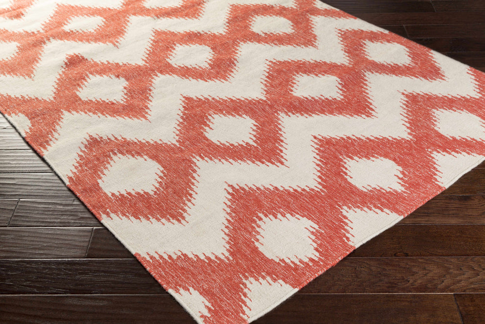 Red and white wool rug with bold zigzag and diamond motif, corner angled