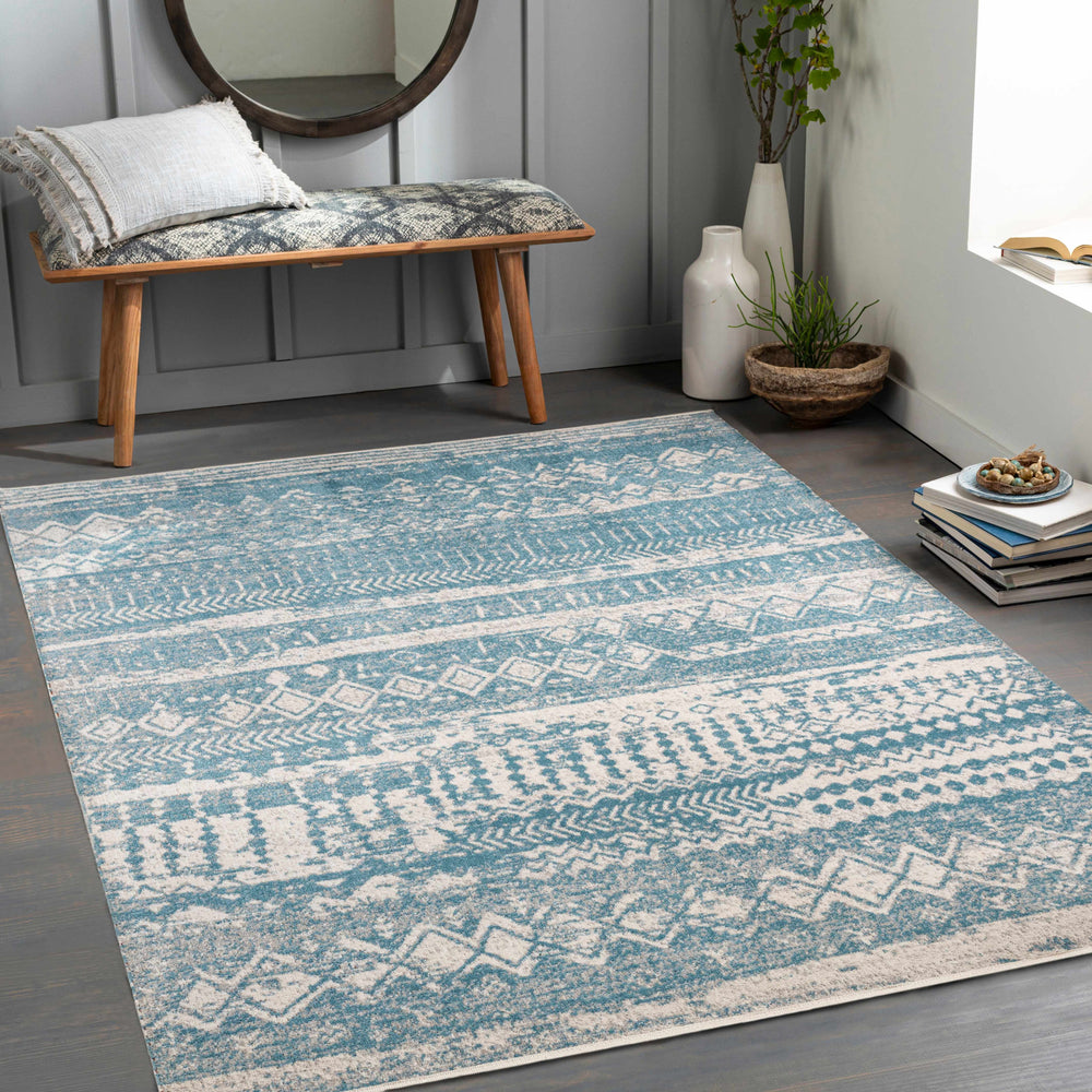 Blue and ivory geometric area rug laid flat in a living room setting.