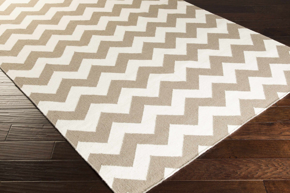 Taupe and ivory chevron area rug corner with repeating zigzag pattern.