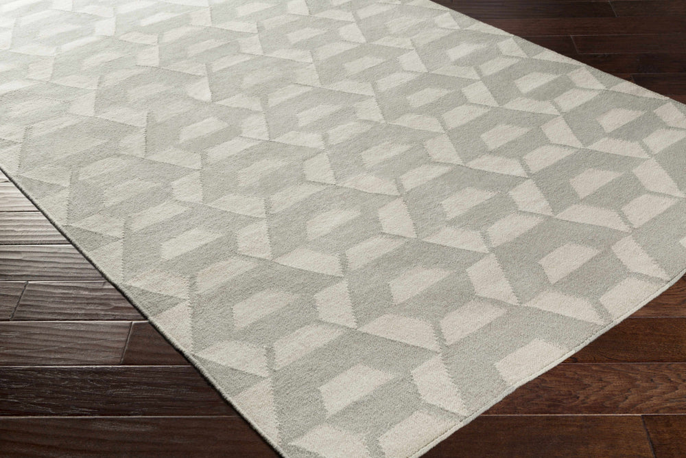 Gray and ivory geometric area rug with repeating hexagon shapes, corner view.
