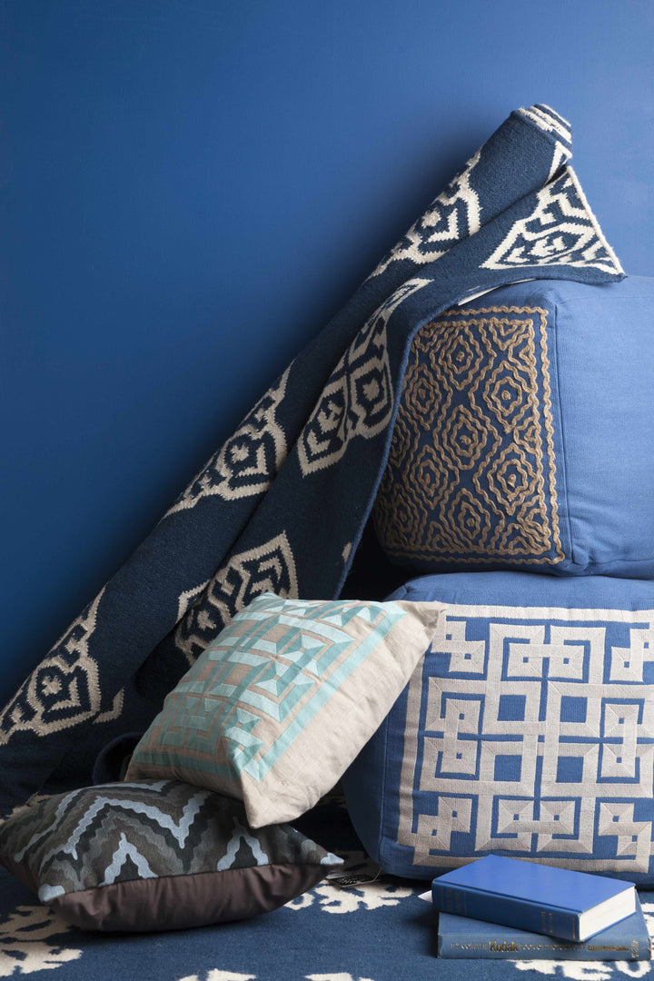 Blue hand-woven rug edge with repeating ivory geometric motifs