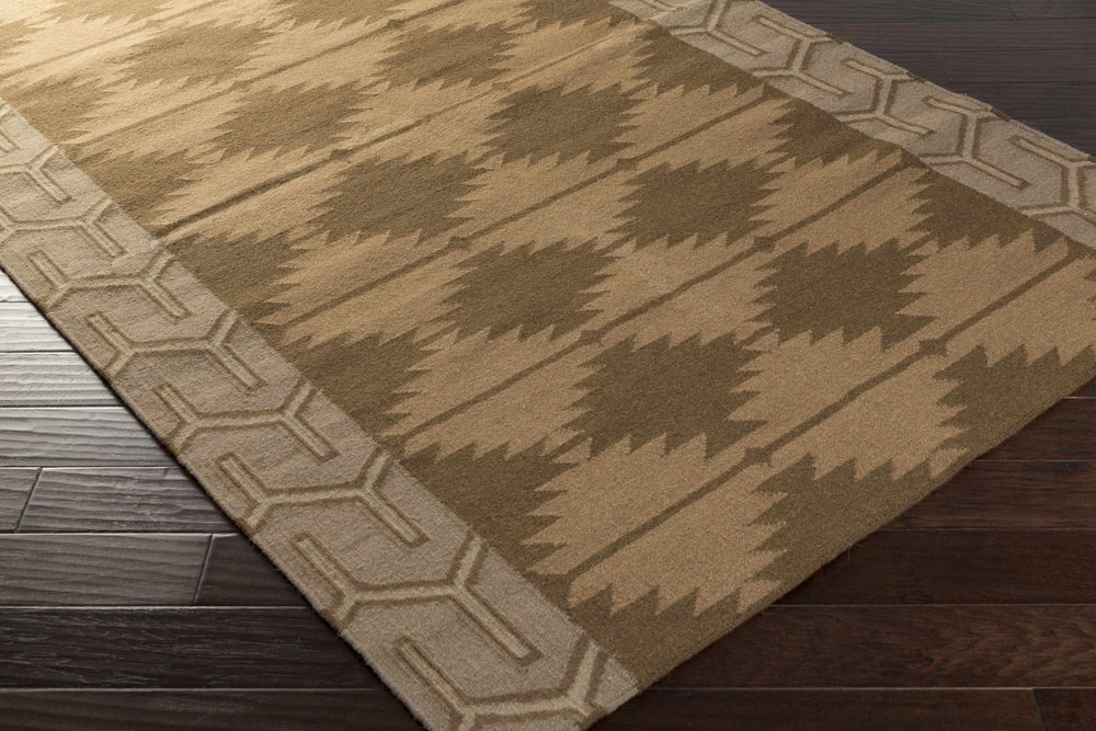 Brown and tan hand-woven wool area rug corner view with geometric pattern border