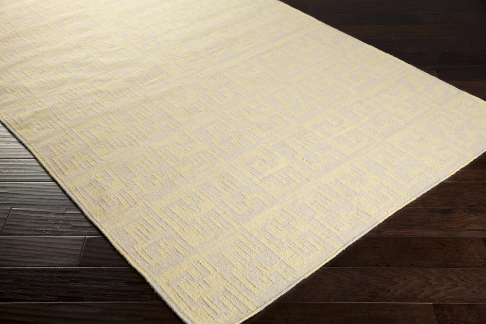Beige hand-woven area rug with geometric lattice pattern and visible woven edge detail.