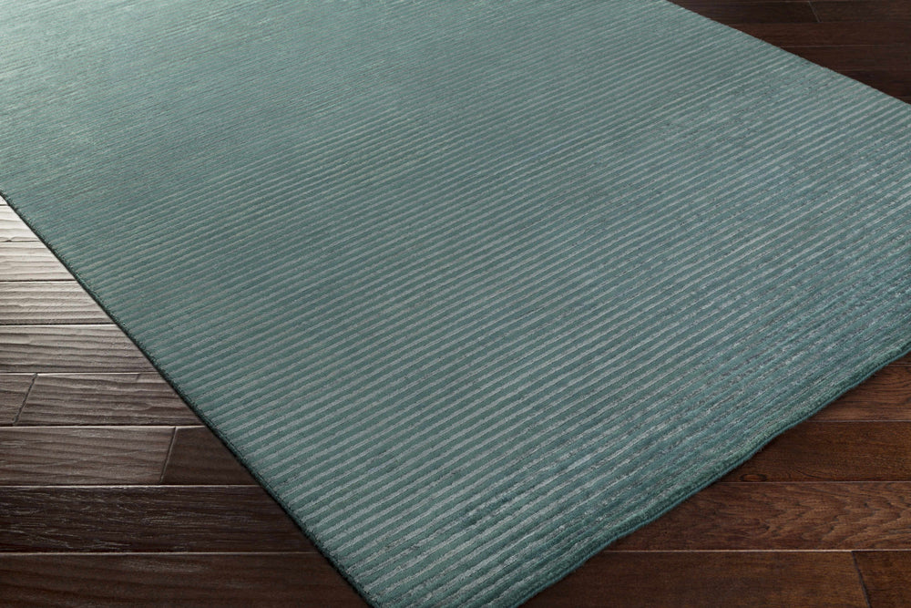 Teal area rug corner with closely spaced horizontal ribbed texture