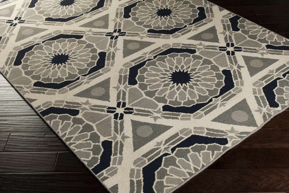 Hand-knotted wool area rug, angled view, black and gray geometric medallion pattern