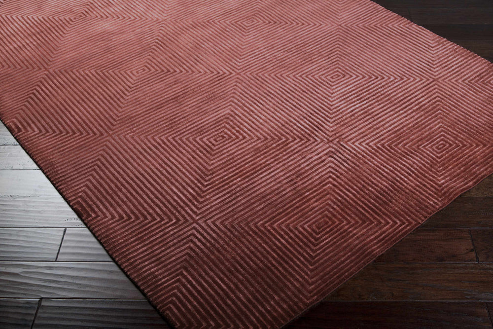 Pink geometric area rug corner view with hand-knotted spiral square pattern