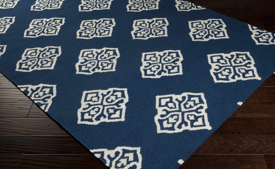 Blue rug with ivory diamond medallion pattern, corner perspective