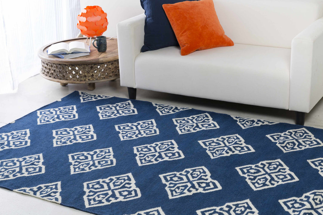 Blue area rug with ivory geometric diamond medallion pattern