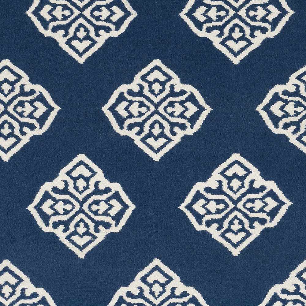 Close-up of blue area rug with ivory diamond medallion motifs