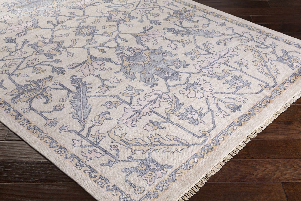 Corner view of traditional area rug with beige background, blue vine pattern, short fringe