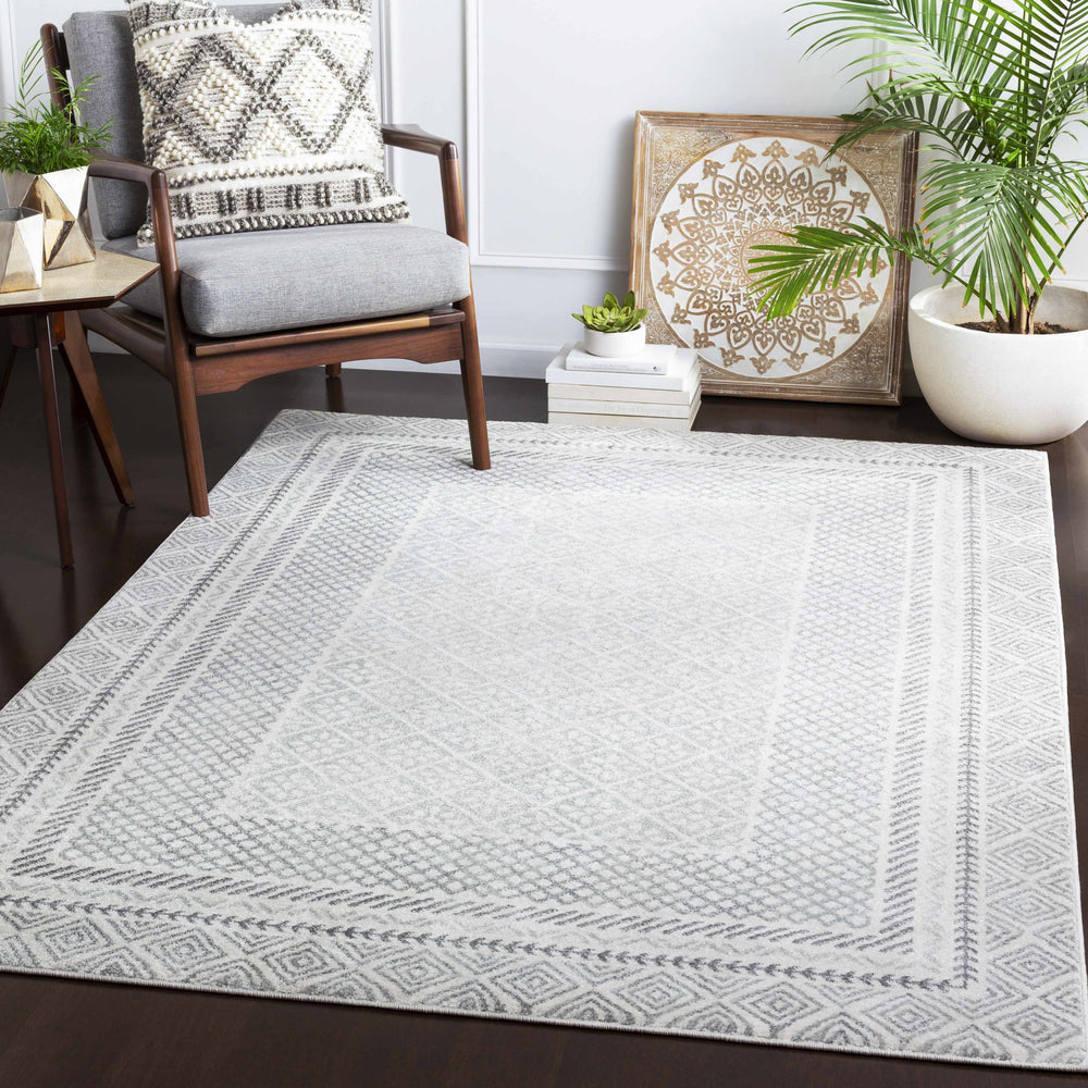 Geometric gray-and-white area rug on floor with zigzag and lattice motifs