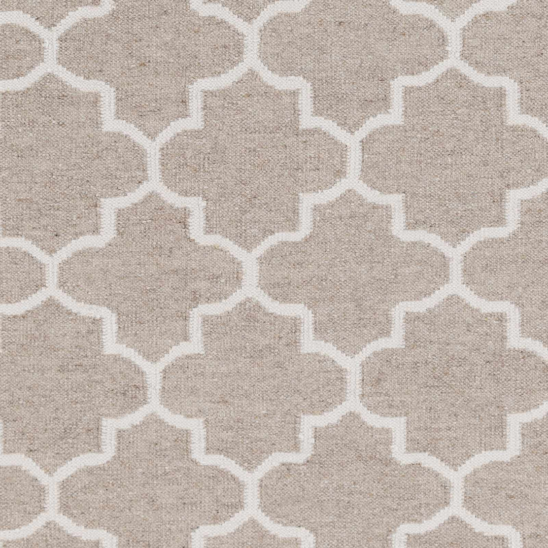 Close-up of beige fabric with ivory four-lobed trellis geometric pattern