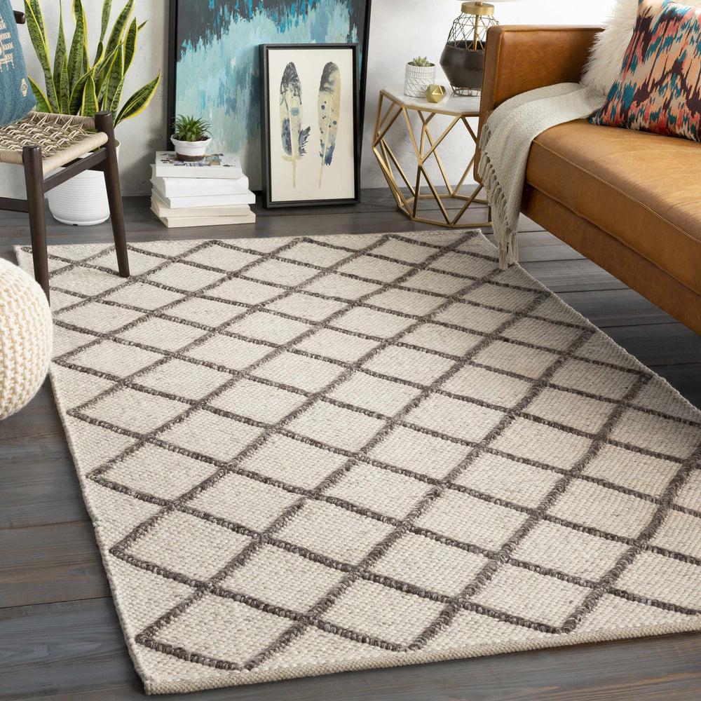 Ivory hand-woven wool area rug with diamond lattice pattern, styled on floor