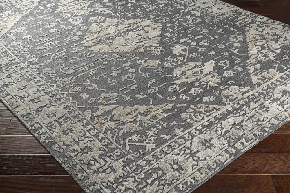 Charcoal and beige hand-loomed area rug corner with distressed geometric motif