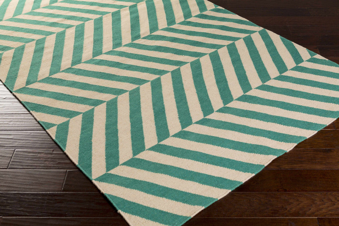 Green and cream chevron patterned area rug shown from an angled top view.