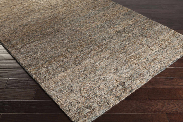 Rectangular brown jute rug with abstract hand-knotted design, angled view