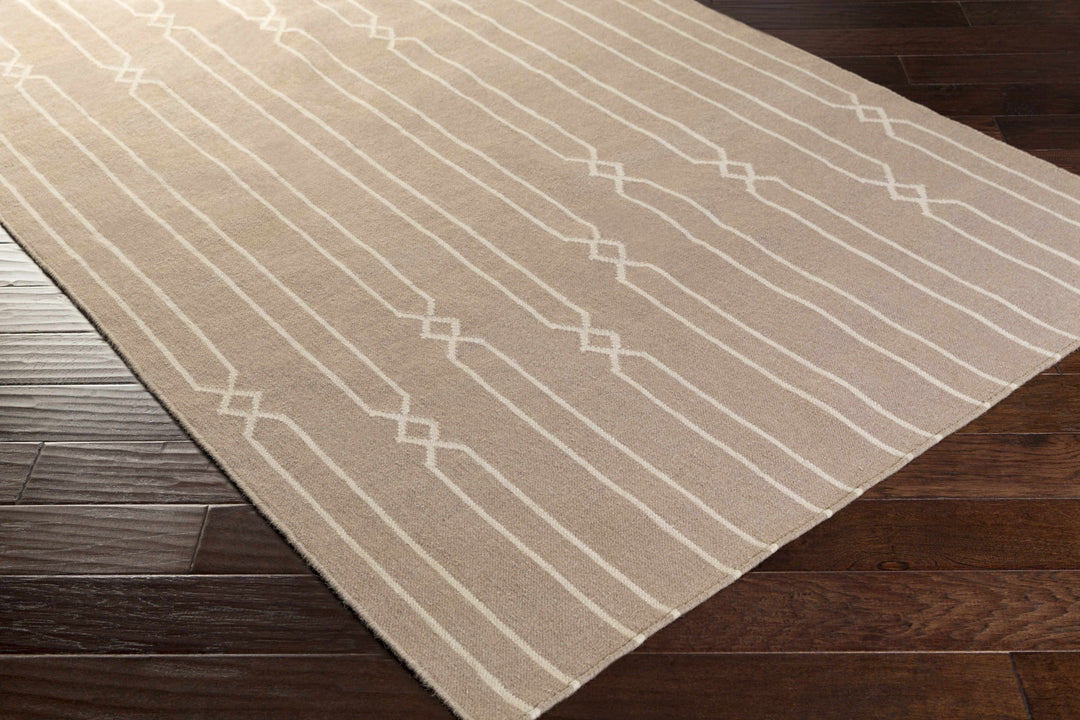 Hand-woven area rug beige and ivory geometric stripe pattern on the floor, corner view