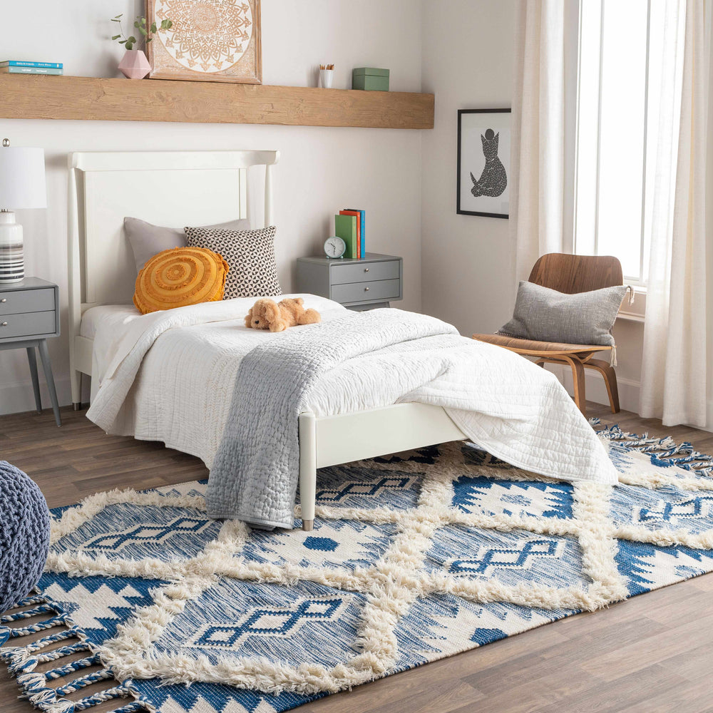 Ivory and blue woven wool area rug with geometric diamond pattern and fringed edges