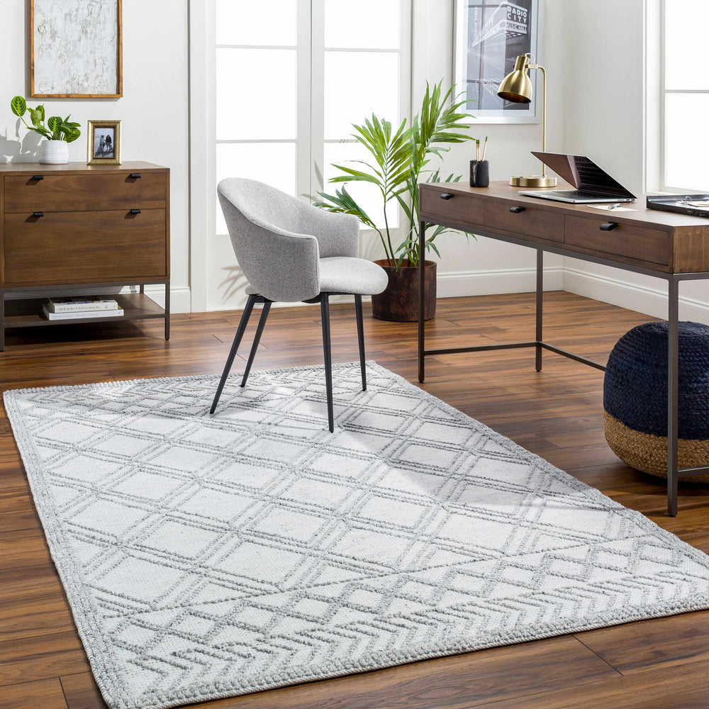 White geometric area rug with diamond lattice pattern on hardwood floor
