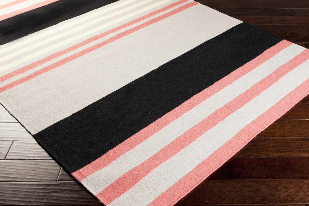 Hand-woven area rug angled view, pink and cream stripes with a wide black band