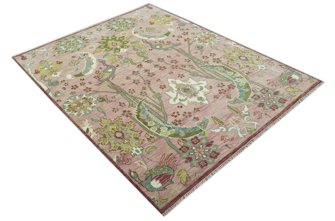 Pink and green hand-knotted wool rug with peacock and floral medallion motif