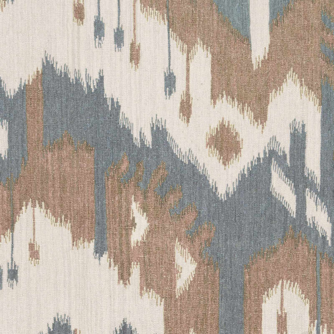 Close-up of abstract area rug weave with blue, beige, brown, and cream shapes