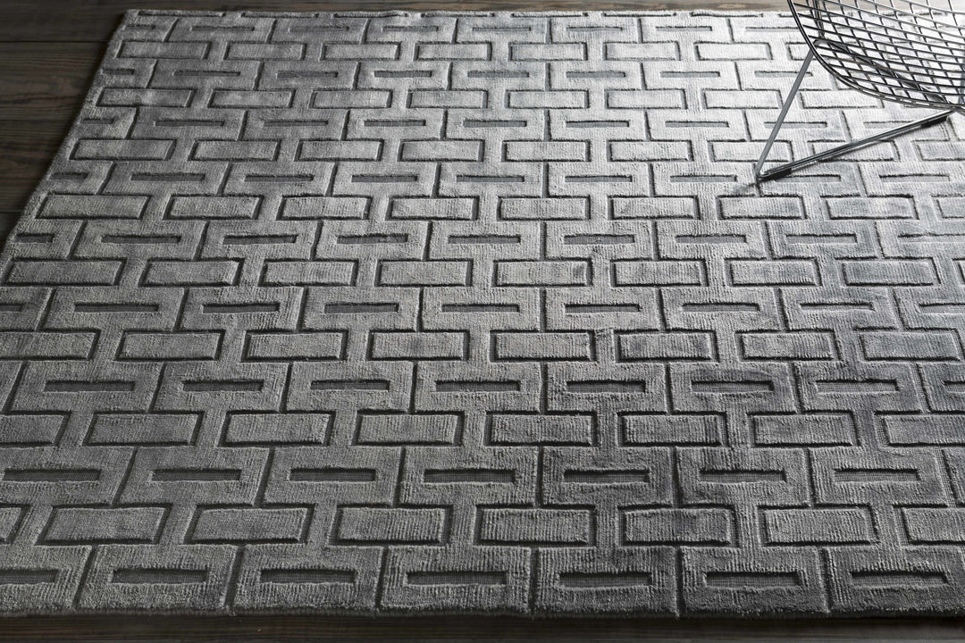Silver and gray geometric area rug with repeating maze-like pattern, wider view
