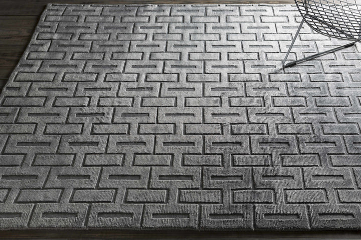 Silver and gray geometric area rug with repeating maze-like pattern, wider view