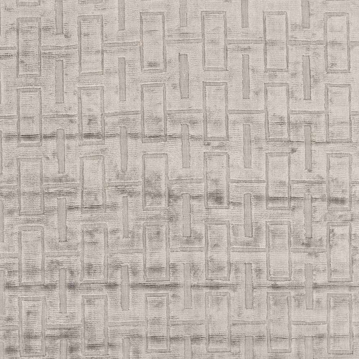 Close-up of light gray and silver geometric rug pattern with raised rectangular blocks