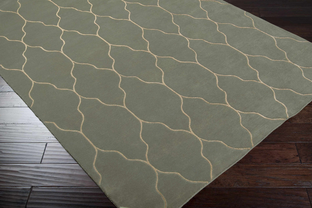 Gray area rug with light trellis geometric pattern, corner angle view on floor
