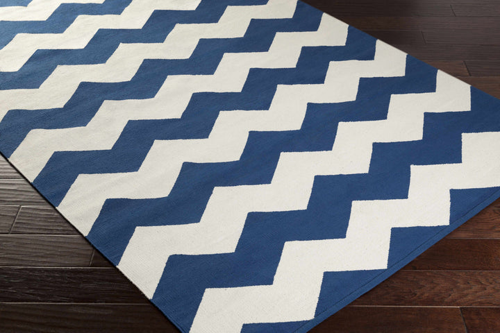 Hand-woven chevron area rug with blue and white zigzag pattern, angled view